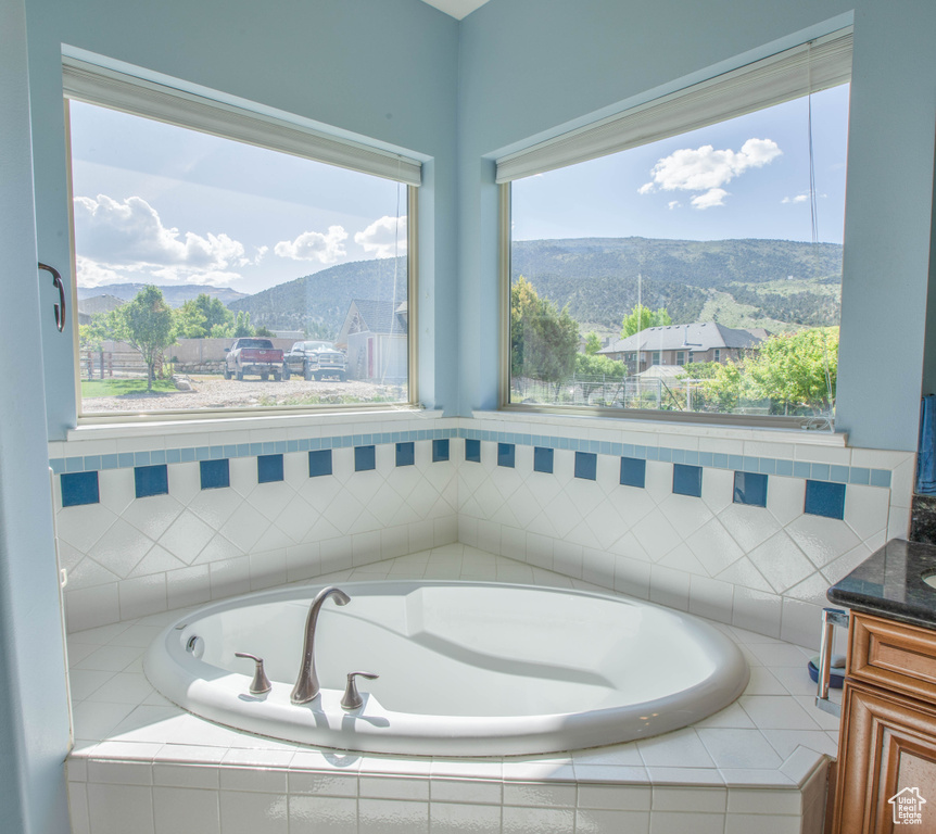 Bathroom featuring vanity, a bath, and a mountain view