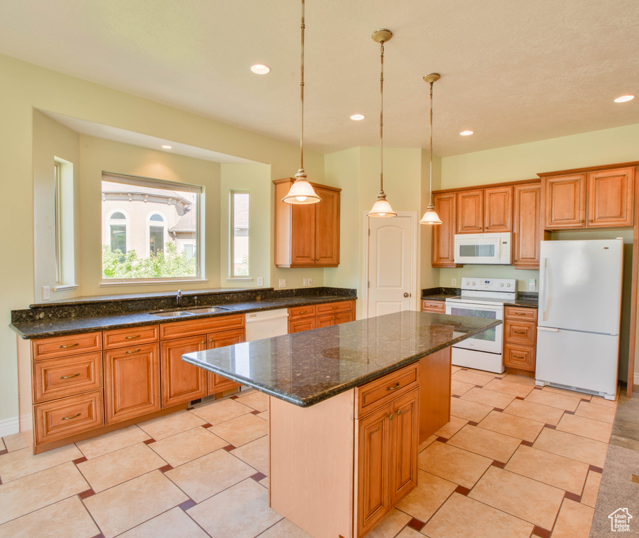 Kitchen with white appliances, a sink, a center island, recessed lighting, and decorative light fixtures