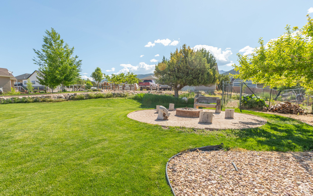 View of yard with an outdoor fire pit and a patio area