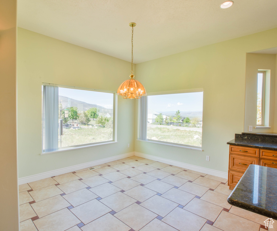 Unfurnished dining area featuring a chandelier, baseboards, and recessed lighting