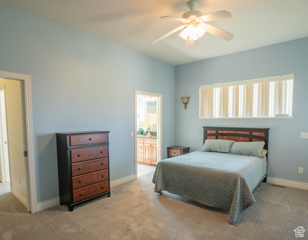 Bedroom with carpet flooring, ensuite bathroom, and baseboards