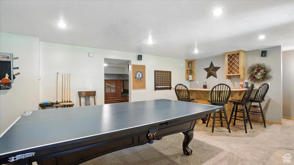 Rec room featuring a bar, carpet floors, recessed lighting, and baseboards