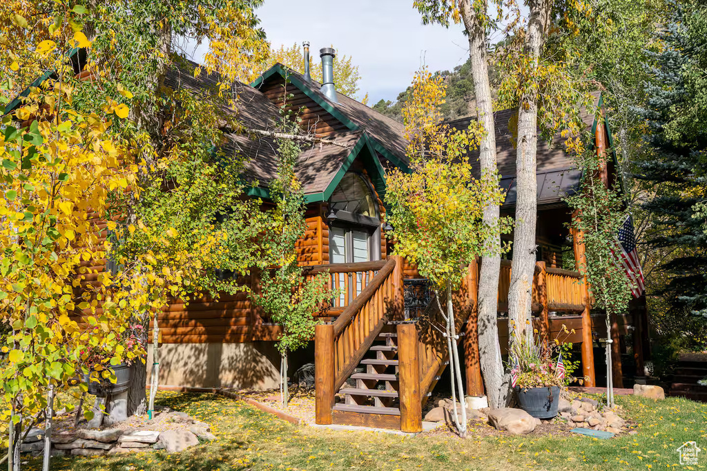 Rear view of property featuring stairs, a deck, and log veneer siding