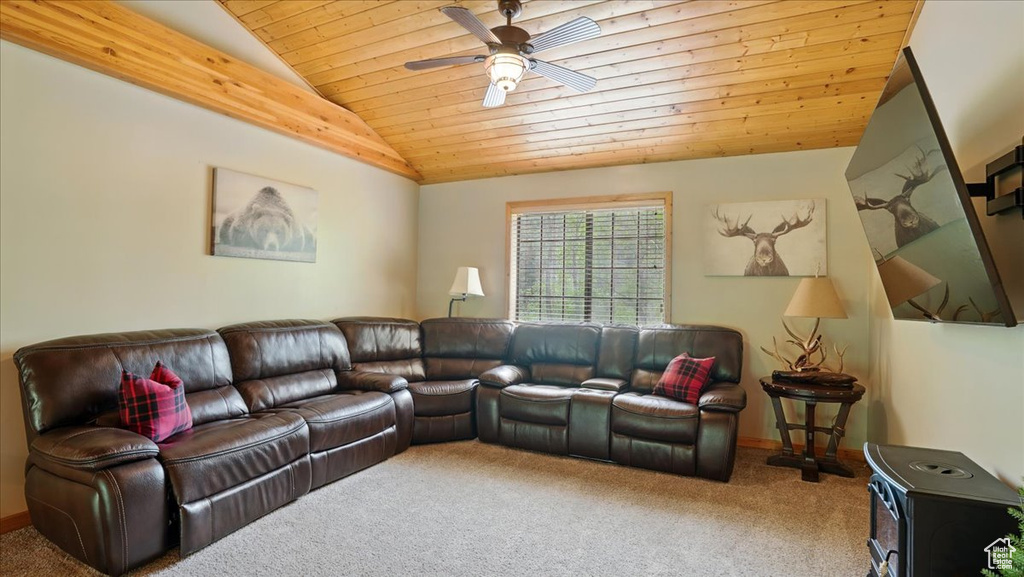 Living room with lofted ceiling, wood ceiling, carpet floors, ceiling fan, and baseboards