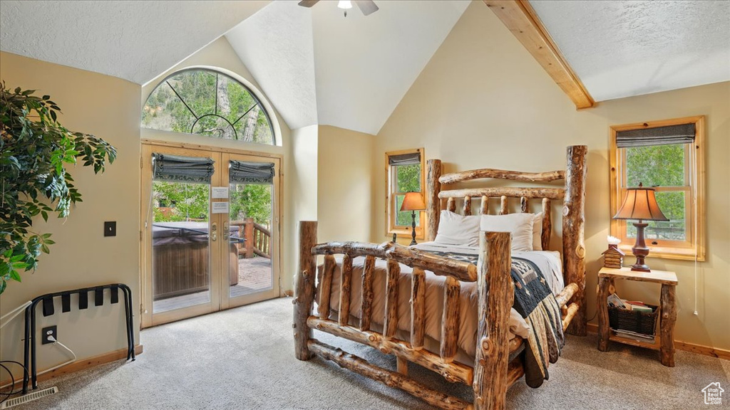 Carpeted bedroom featuring access to exterior, vaulted ceiling, multiple windows, a textured ceiling, and baseboards