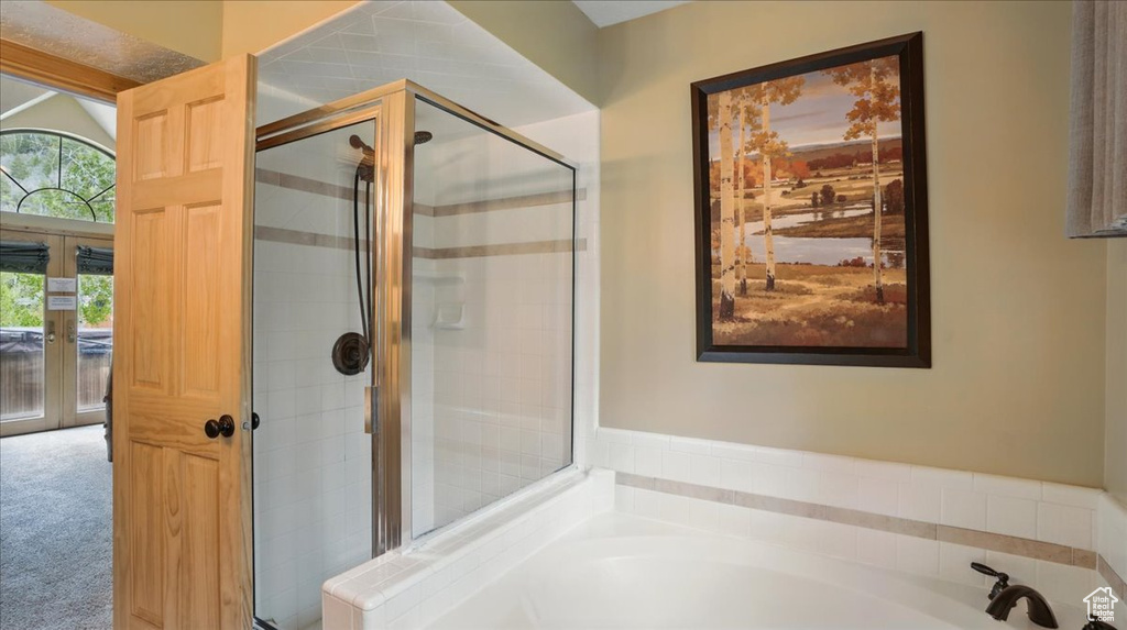 Bathroom featuring a garden tub and a shower stall