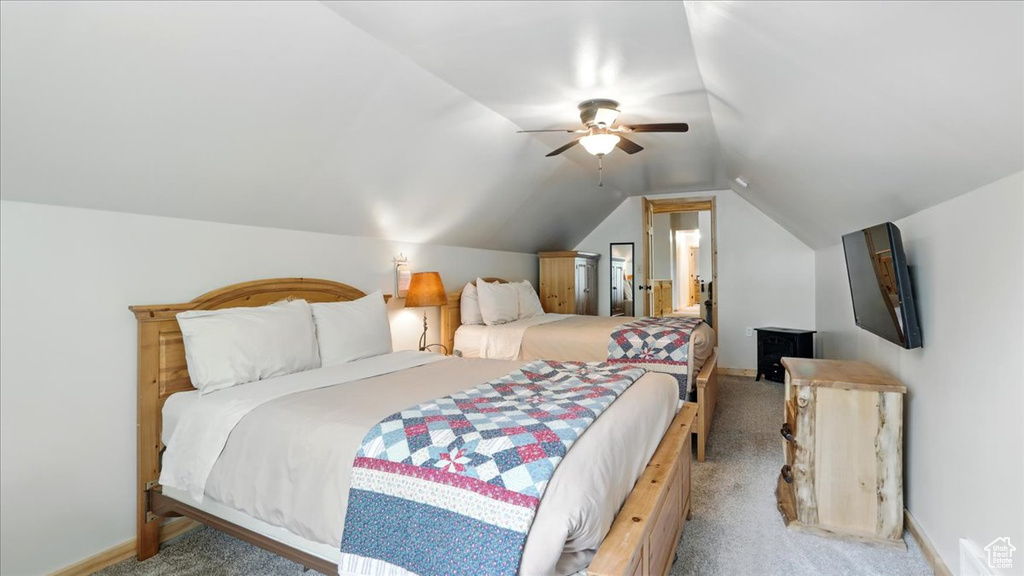 Bedroom with light colored carpet, vaulted ceiling, baseboards, and ceiling fan