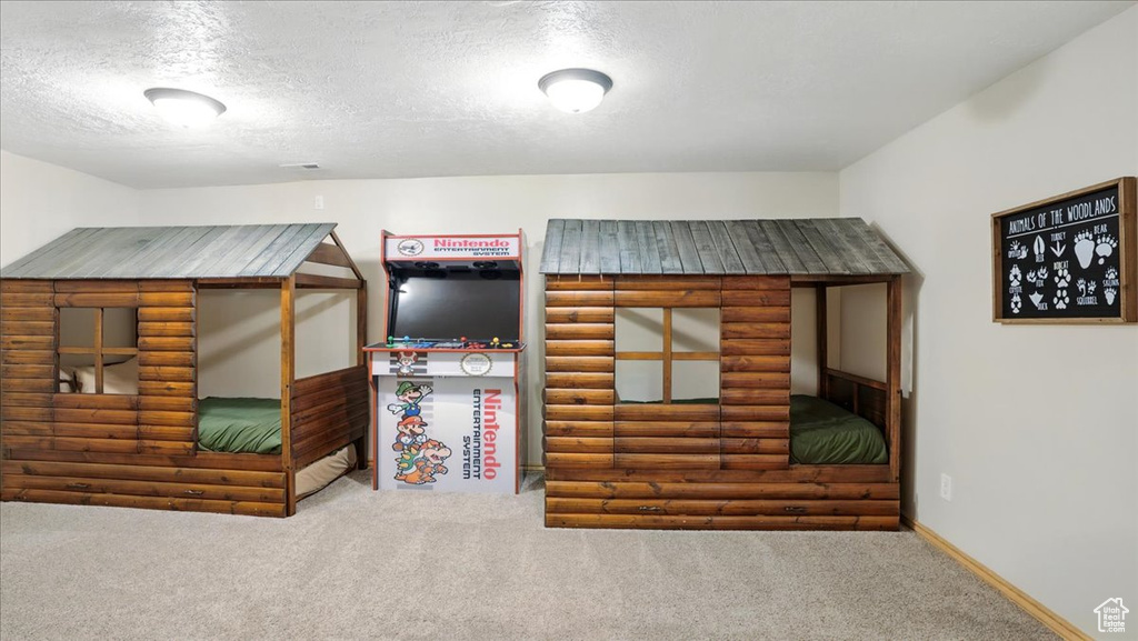 Unfurnished bedroom featuring carpet flooring, a textured ceiling, and baseboards