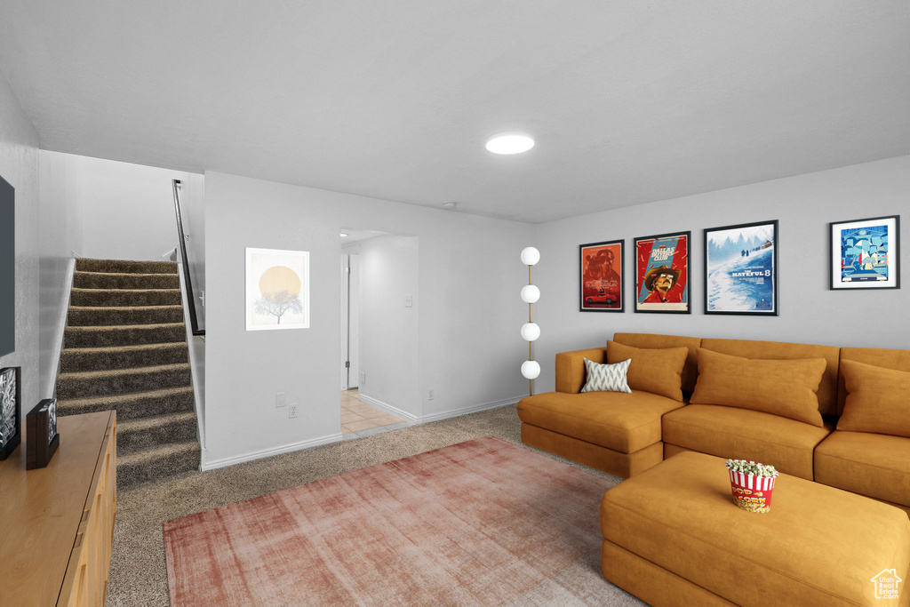 Living room with light carpet, stairs, and baseboards