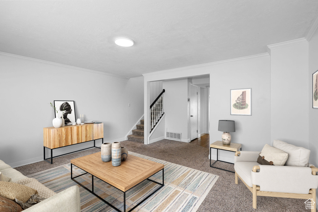Living area featuring stairway, carpet, crown molding, and baseboards