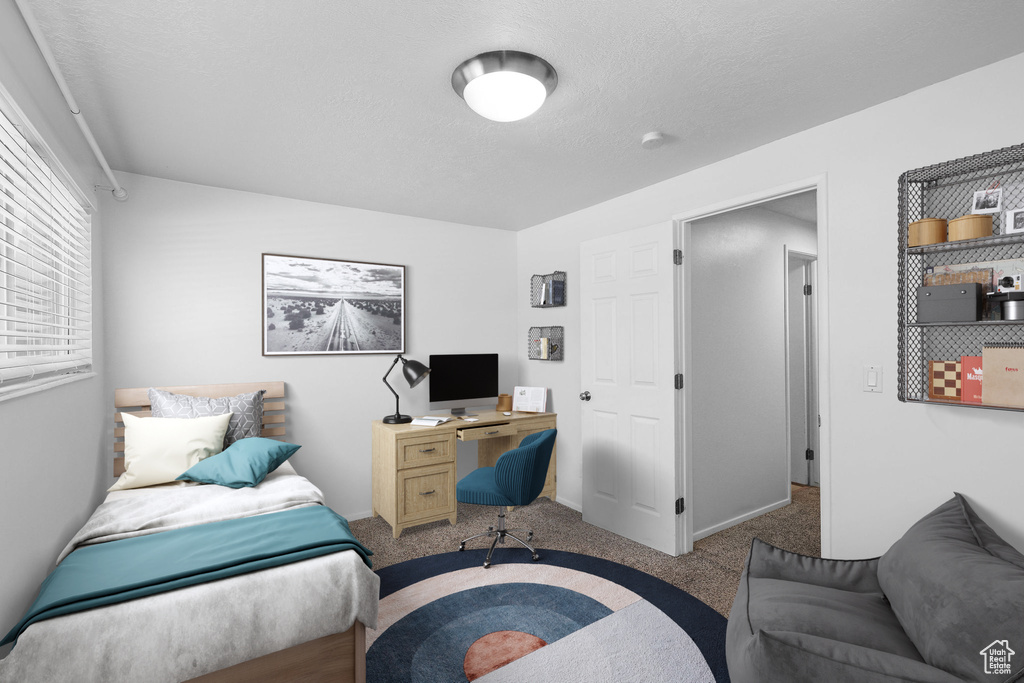 Carpeted home office featuring a textured ceiling and baseboards