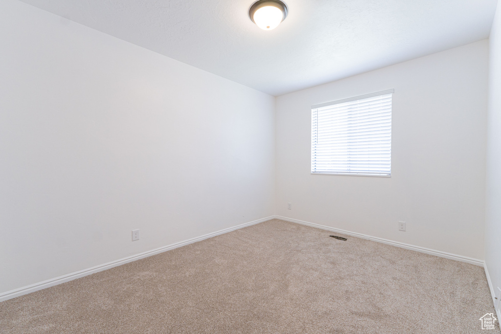 Unfurnished room with carpet and baseboards