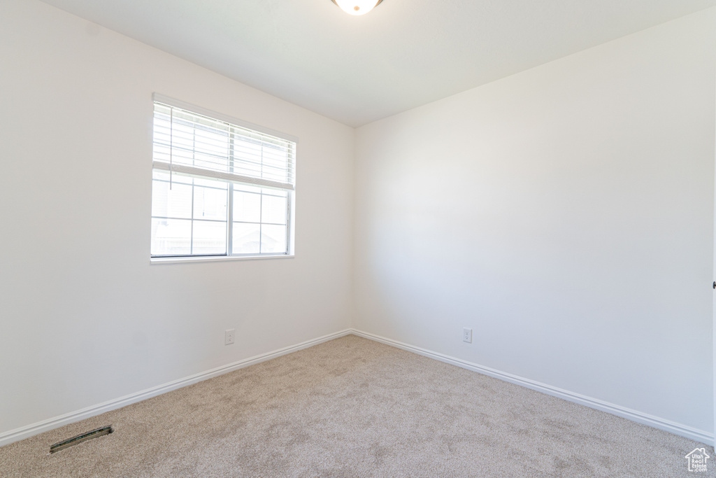 Spare room featuring carpet floors and baseboards