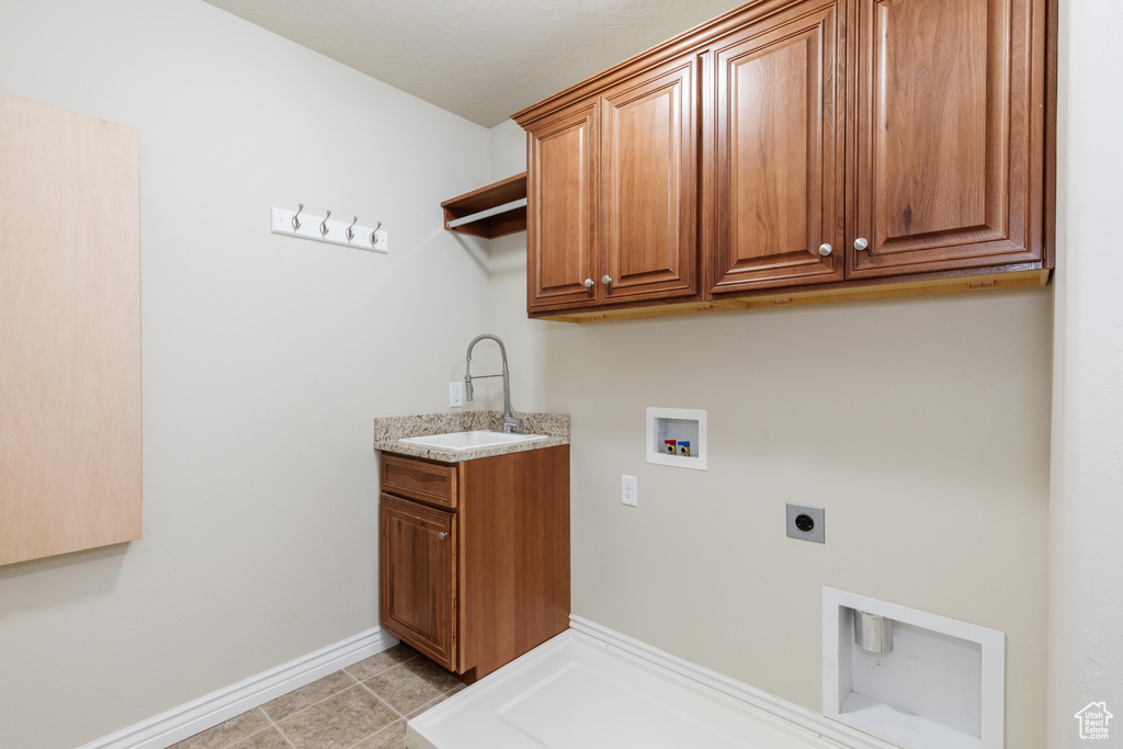Laundry room with hookup for an electric dryer, cabinet space, hookup for a washing machine, baseboards, and light tile patterned flooring