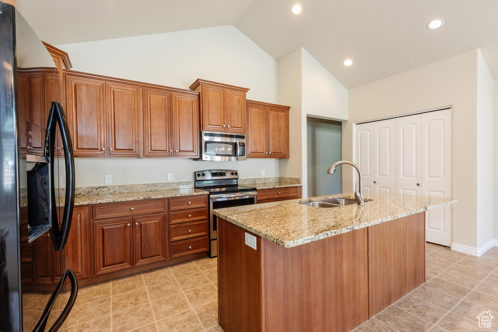 Kitchen featuring appliances with stainless steel finishes, a sink, high vaulted ceiling, brown cabinets, and light stone counters