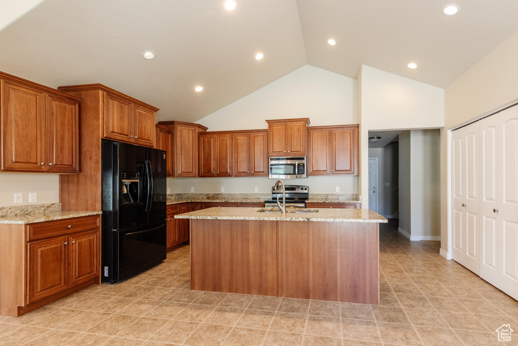 Kitchen featuring appliances with stainless steel finishes, high vaulted ceiling, a sink, a kitchen island with sink, and brown cabinetry