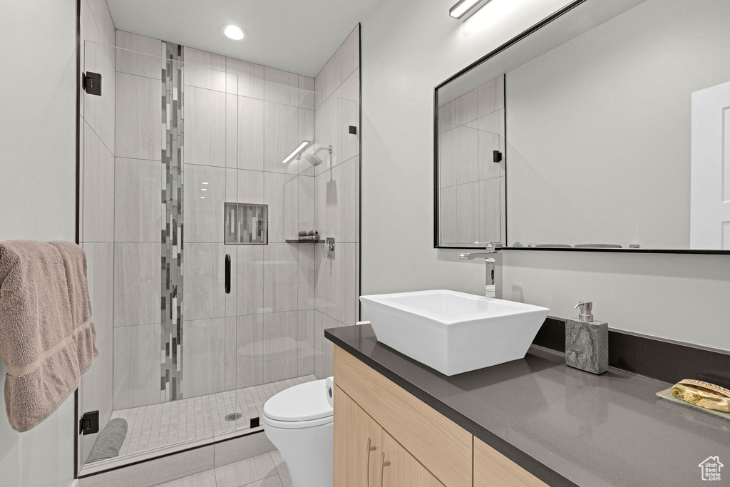 Full bathroom featuring toilet, vanity, a shower stall, and recessed lighting