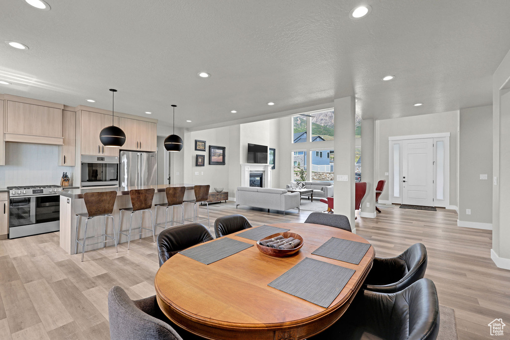 Dining room with recessed lighting, light wood-style flooring, and baseboards