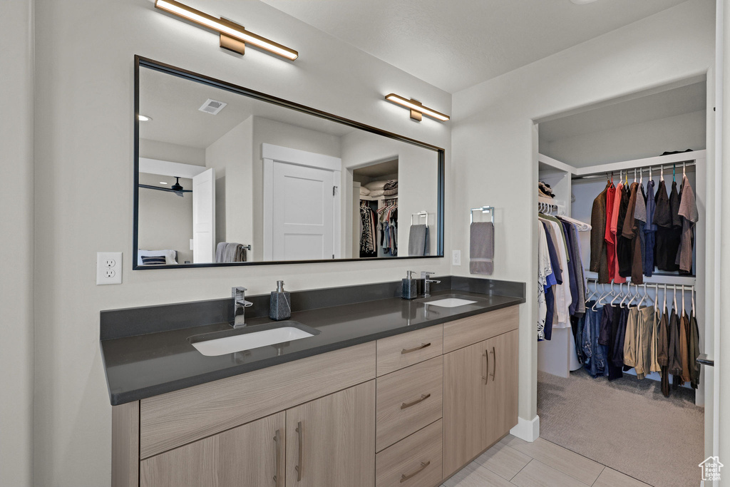 Bathroom featuring double vanity and a walk in closet