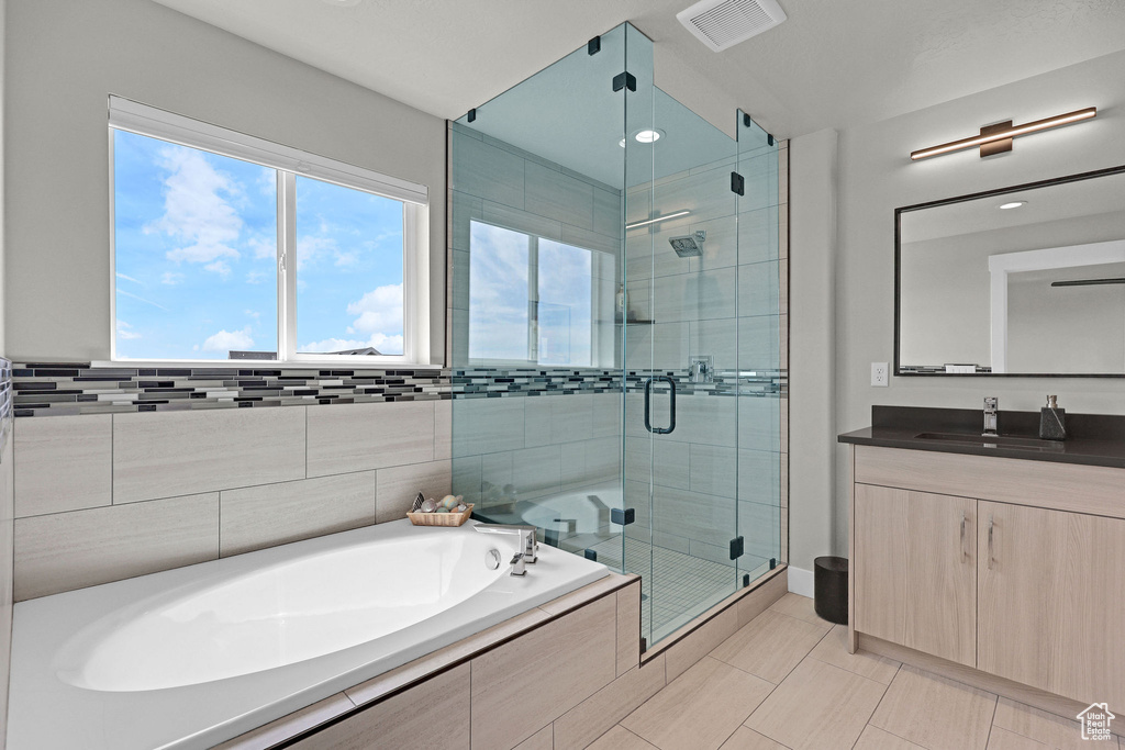 Full bathroom featuring a garden tub, vanity, a shower stall, tile patterned floors, and recessed lighting