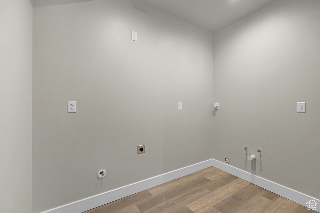 Laundry room featuring hookup for a gas dryer, hookup for an electric dryer, light wood-type flooring, baseboards, and washer hookup
