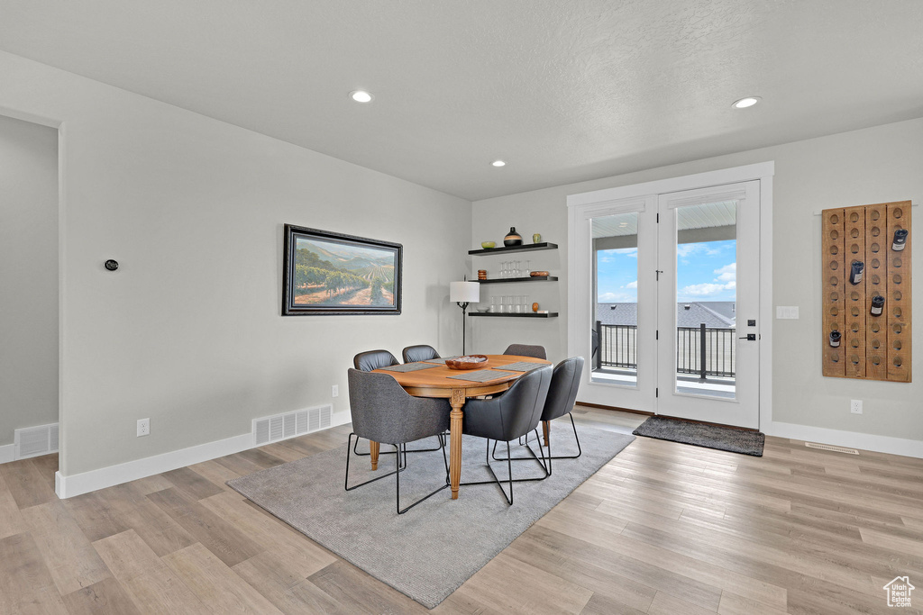 Dining room with light wood-style floors, baseboards, and recessed lighting