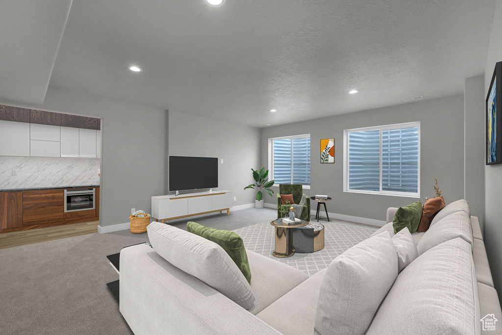 Carpeted living room featuring recessed lighting, baseboards, and wine cooler