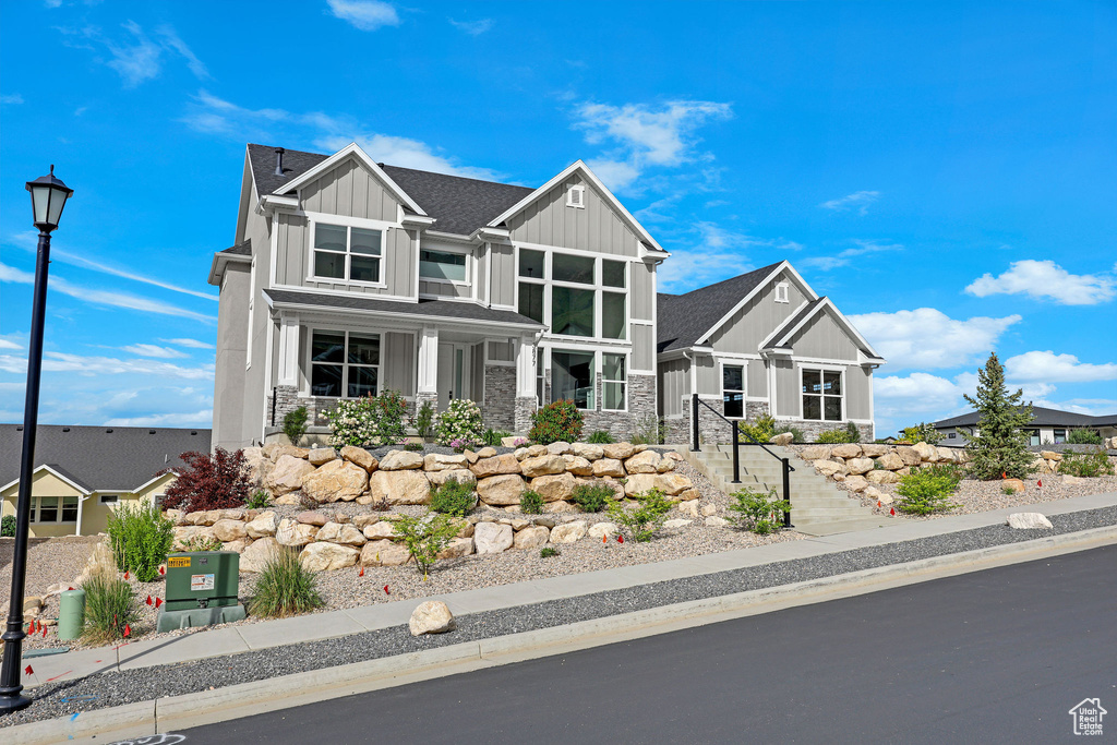 Craftsman house featuring board and batten siding and stone siding