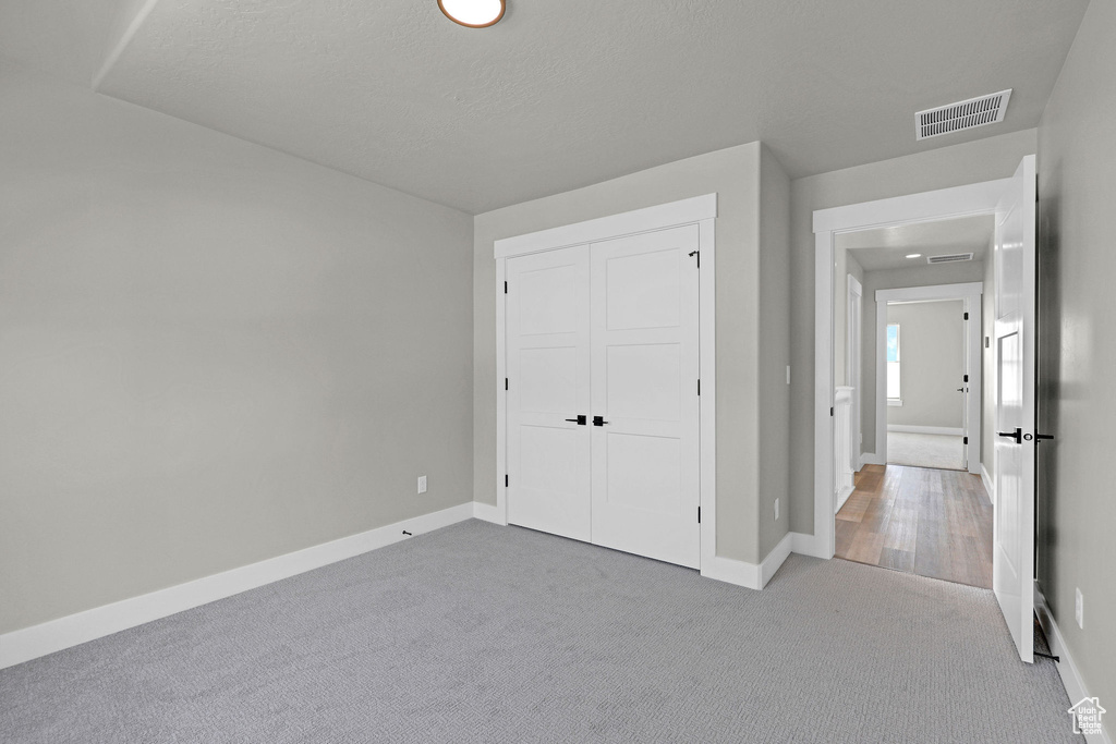 Unfurnished bedroom with carpet flooring, baseboards, and a closet