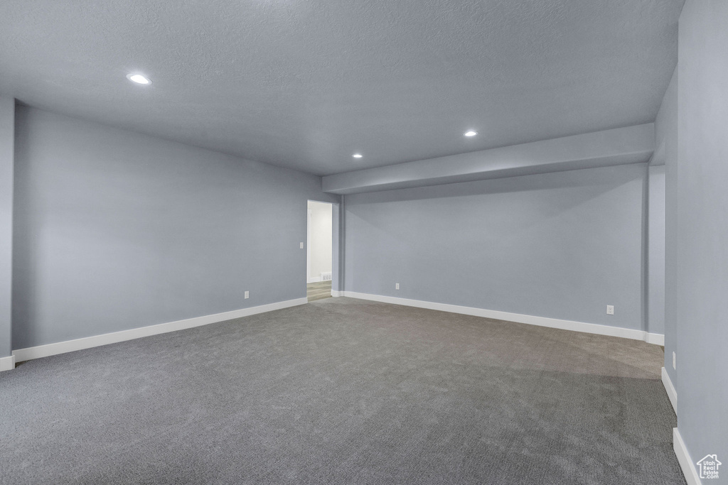 Carpeted spare room featuring recessed lighting, a textured ceiling, and baseboards