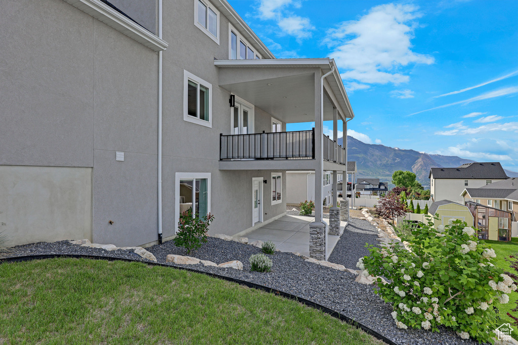 Exterior space with a balcony, a mountain view, and a patio area