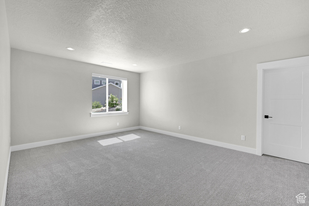 Unfurnished room with carpet flooring, a textured ceiling, recessed lighting, and baseboards