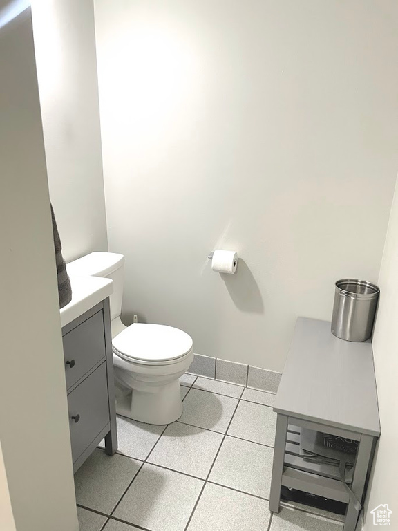 Bathroom featuring vanity, toilet, and tile patterned flooring