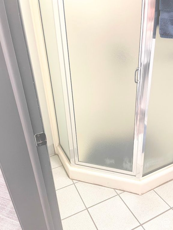 Bathroom featuring a shower stall and tile patterned floors