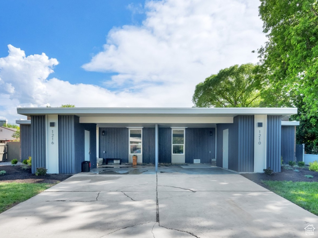 View of front facade with board and batten siding and concrete driveway