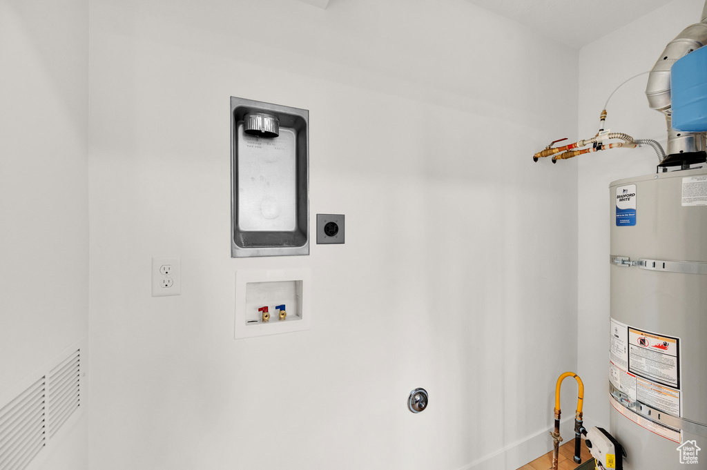 Laundry area with electric dryer hookup, water heater, washer hookup, and wood finished floors