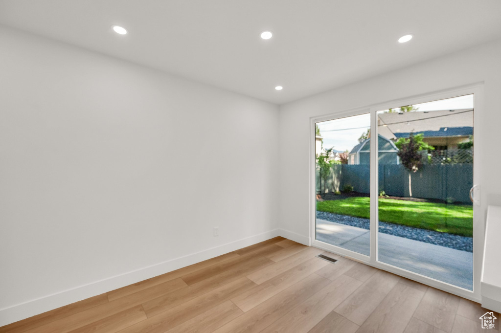 Spare room with light wood-type flooring, baseboards, and recessed lighting