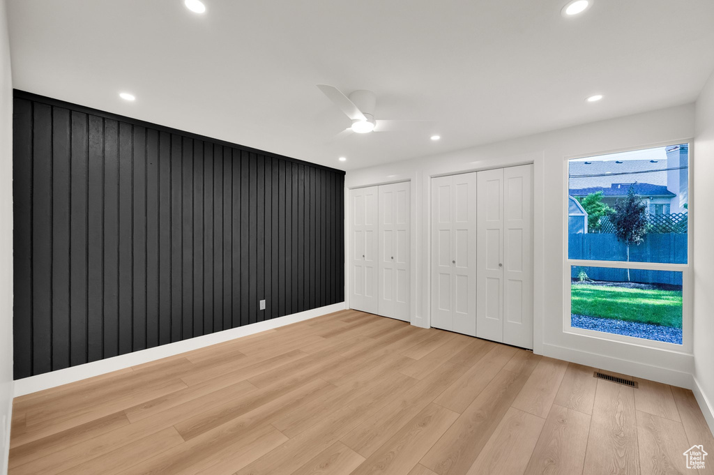 Unfurnished bedroom with multiple closets, light wood-type flooring, recessed lighting, and a ceiling fan
