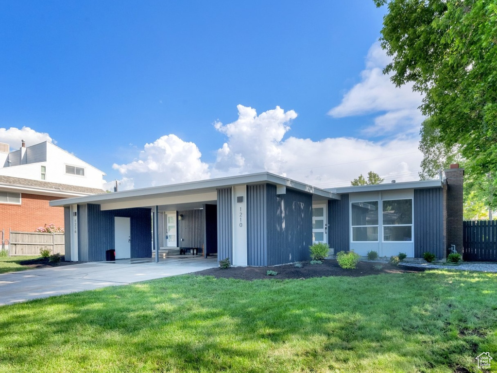 View of front of house featuring concrete driveway and an attached carport