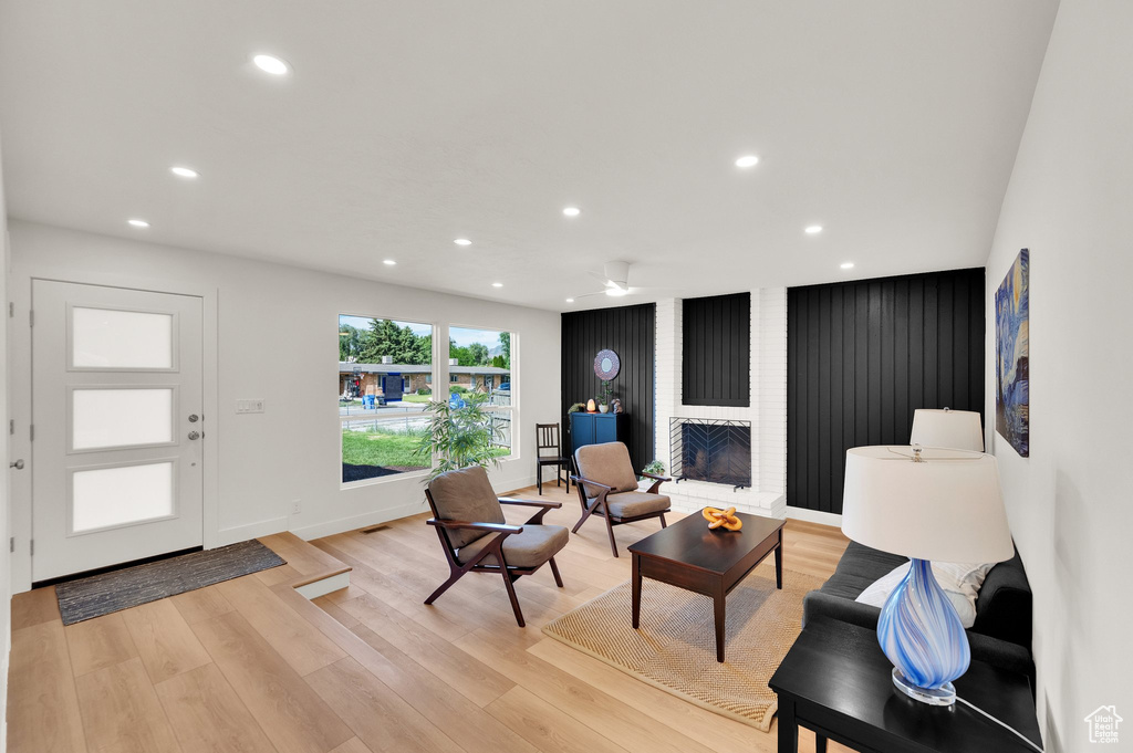 Living room featuring recessed lighting, light wood-style flooring, a fireplace, baseboards, and a ceiling fan