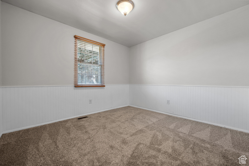 Carpeted empty room with wainscoting