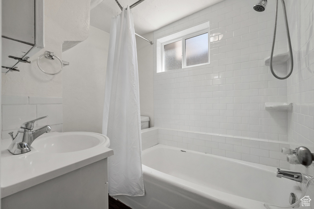 Full bathroom with shower / bath combo with shower curtain and vanity