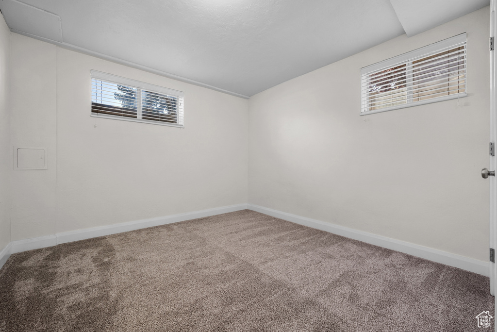 Carpeted spare room featuring baseboards
