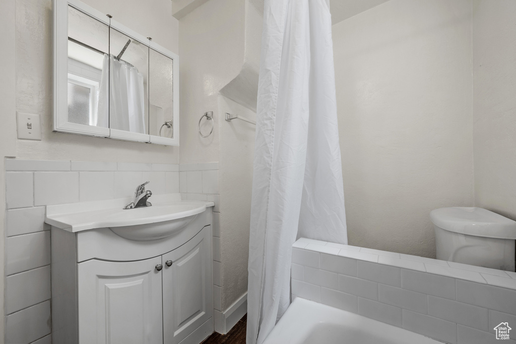 Full bath featuring vanity, toilet, and wood finished floors