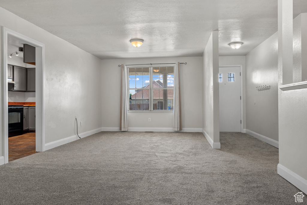 Entrance foyer with carpet floors and baseboards