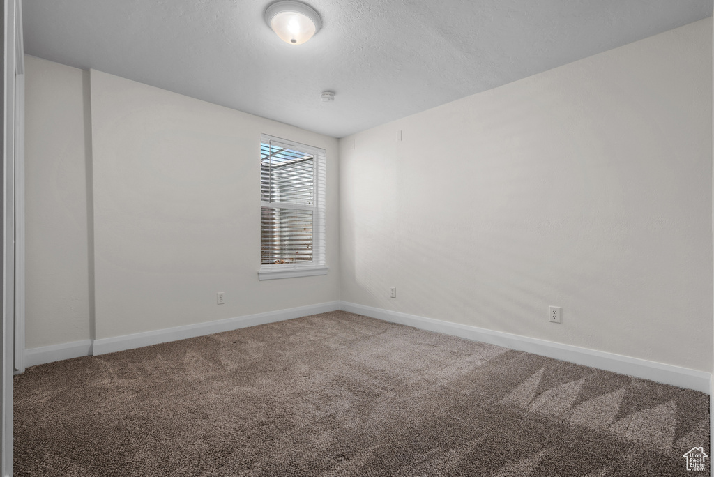 Carpeted spare room with baseboards