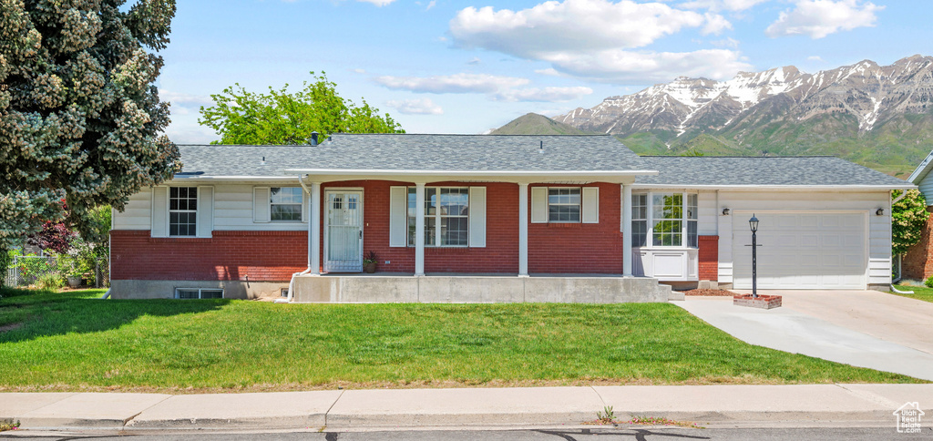 Ranch-style home with a garage, concrete driveway, a front yard, and brick siding