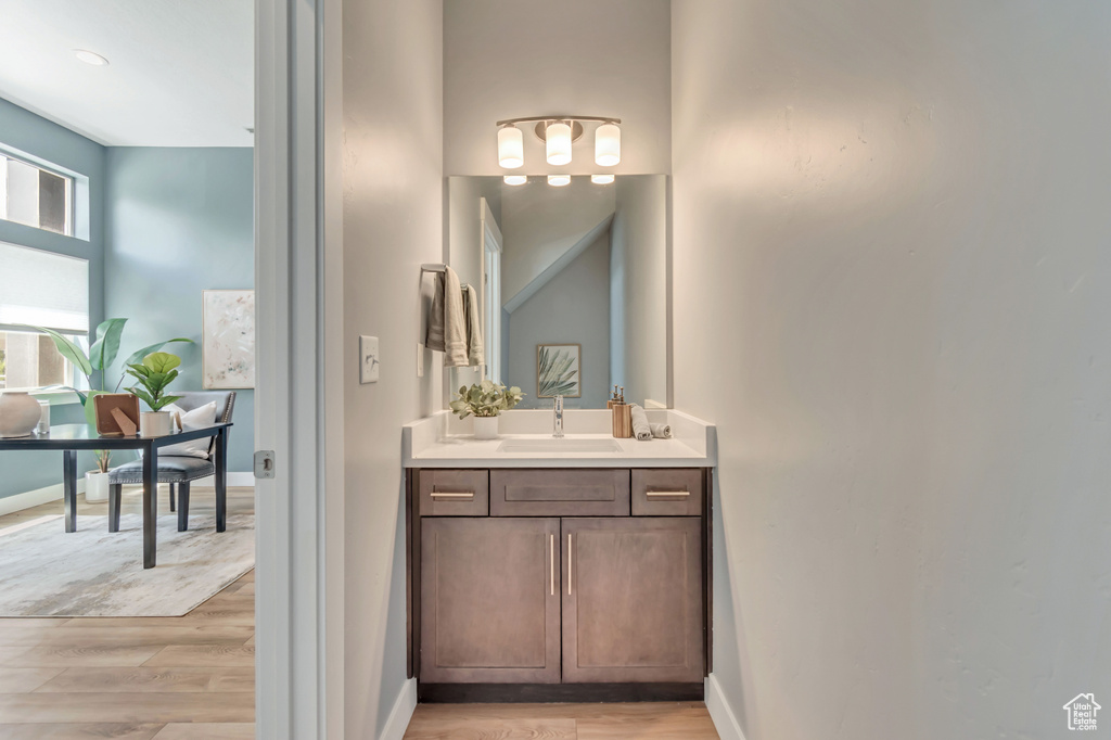Bathroom featuring wood finished floors, vanity, and baseboards
