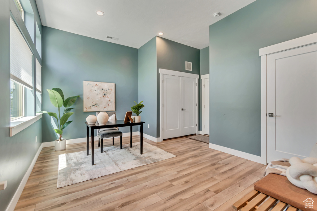 Office area featuring wood finished floors, baseboards, a high ceiling, and recessed lighting