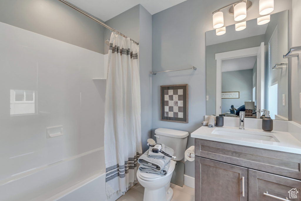 Full bathroom with toilet, vanity, shower / bathtub combination with curtain, baseboards, and tile patterned flooring